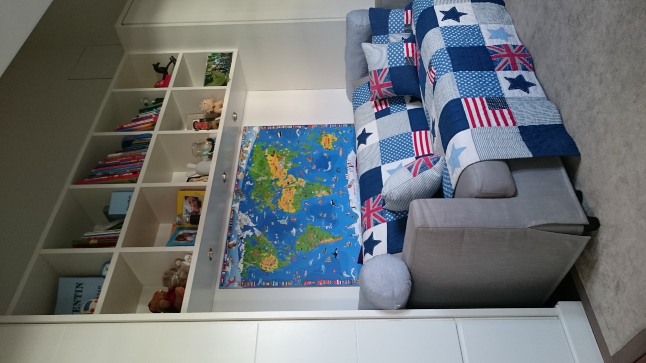 Kinderzimmer mit Regalwand, Weltkarte und Sofa