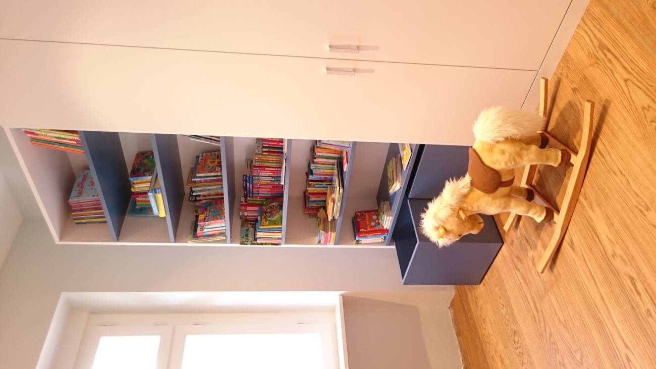 Blaues Bücherregal mit Schaukelpferd