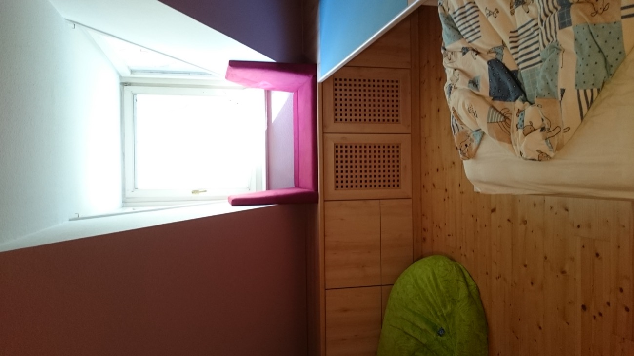 Dachgeschoss-Kinderzimmer mit Fensterbank und Stauraum