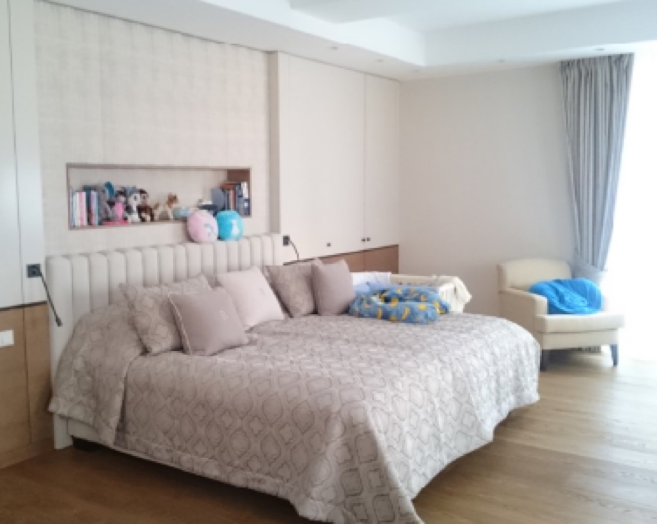 Schlafzimmer mit maßgefertigter Schrankwand in Beige und gepolstertem Bett