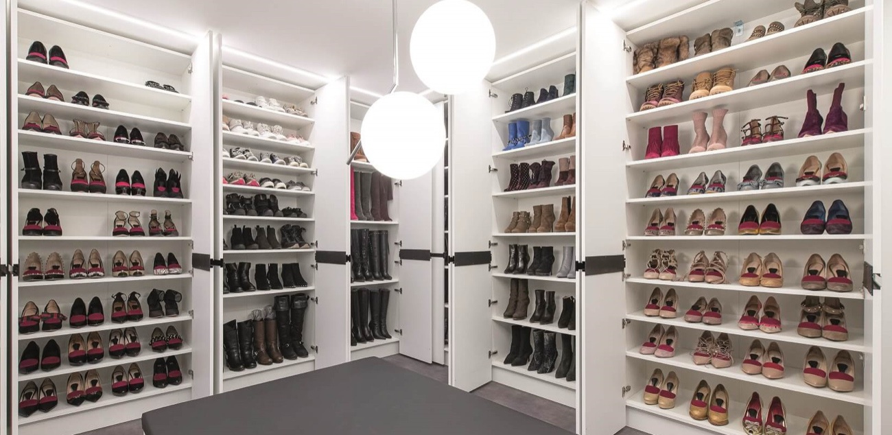 Begehbarer Schrankraum mit beleuchteten Schuhregalen vom Boden bis zur Decke